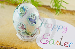 Hand painted decoupage Easter egg on a wooden surface