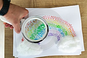 Hand painted drawing rainbow with a loupe on a white paper photo