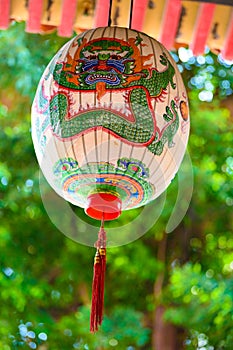 Hand-painted lantern in Taiwan. Hand painted lampion with frightening dragon face in green and red on white photo