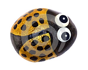 A hand painted pebble of a smiling little bug.