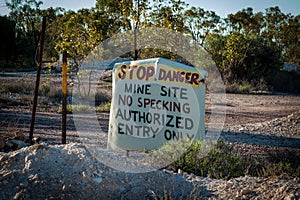 Hand painted sign for stop danger mine site no specking authorized entry only