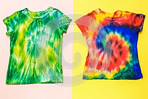 Hand-painted two tie dye t-shirts on a two-tone background. Flat lay.