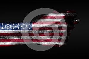 A hand with a painted USA flag shows a barreling, a sign of aggression, disagreement, a dispute on a dark background