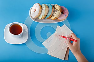 Hand painting heart with tea and donuts