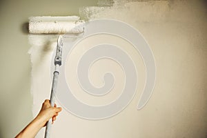 Hand painting wall with paint roller, pastel color. Appartment renovation, repair, building and home concept. Copy space