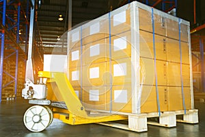 Hand pallet truck or hand forklift with large shipment pallet goods at warehouse stoeage. photo