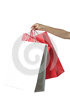 Hand with paper bags on the white background - studio shoot, shopping and consumerism concept