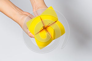 Hand in a paper fortune teller  on white background