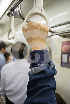 Hand of passengers hold on rail handle of transit system