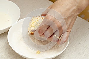 Hand passing in grated coconut traditional Brazilian dessert known as BOLO GELADO photo