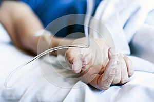 Hand of patient in serious condition is given a medicine through a dropper healthcare background with an intravenous system