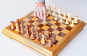 Hand with pawn makes first move on chess Board