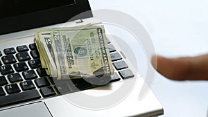Hand paying throwing buch dollar us banknotes or laptop keyboard