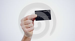 Hand, payment and closeup of credit card in a studio for online shopping, paying bills or debt. Ecommerce, money and