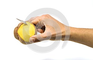 A hand peeling a potatoe