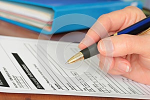 Hand with Pen Completing Personal Info on Form