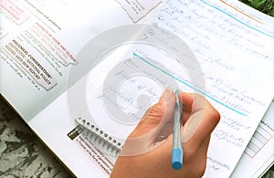 Hand with pen on exercise book