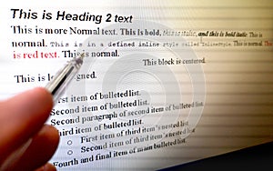 Hand with pen indicate text formatting rules on word processor software on computer screen photo
