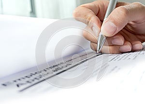 Hand with pen over application form