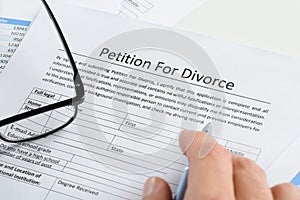 Hand with pen on petition for divorce paper photo