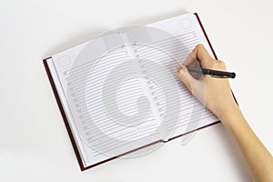 Hand with pen is ready to write in an open notebook