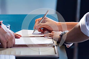 Hand with pen signing document, close up