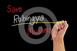 Hand with pen writing Save Rohingya Muslims from human trafficking isolated on black background