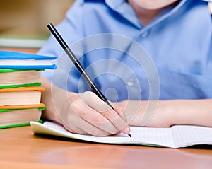 Hand with pencil writing in a notebook