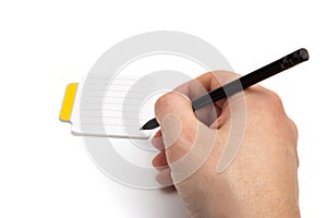 Hand with pencil writing on small lined sticky notes isolated on white background
