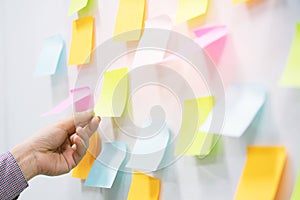 hand people business man  notes pad in the wall at meeting room. Sticky post it note paper reminder schedule board.