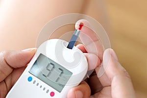 Hand of people check diabetes and high blood glucose monitor with digital pressure gauge. Healthcare and Medical concept