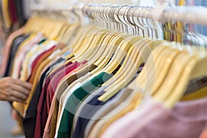 Hand of people are choosing Colorful T-shirt on the clothes rack in the mall