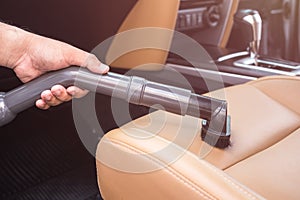 Hand of people holding vacuum cleaner and cleaning inside the SUV car