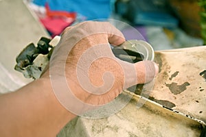 Hand of people are opening to oil cover of motorcycle for checking oil remain in tank