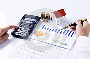 Hand people pointing calculator and fountain pen on business chart with coins stack and house paper for loans concept