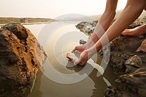 Hand of people taking dirty water from the drying pond