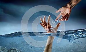 Hand of person drowning in water