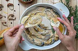 Hand of a person holding baked mussel