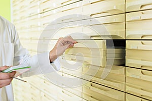 Hand of pharmaceutist opening drawer in farmacy