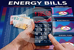 Hand with phone calculator app analyzing energy bill expenses, Concept High cost of energy bill