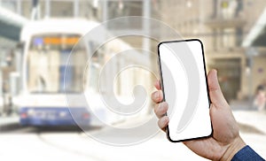 Hand with phone on the White background of the city bus. The idea for the app purchase an e-ticket for public transport, reading t