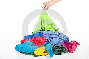 Hand pick up shirt in pile of clothes