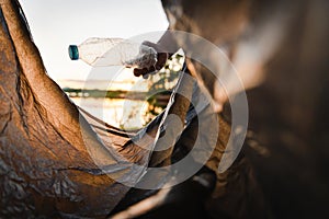 hand picking up garbage plastic bottle for cleaning at park