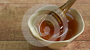 Hand picking wooden honey scoop from cup