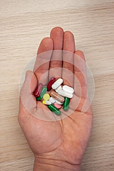 Hand with pills of different colors photo