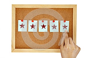 Hand pin a note paper on cork pin board with give five star , symbol of excellent customer satisfaction feedback concept ,
