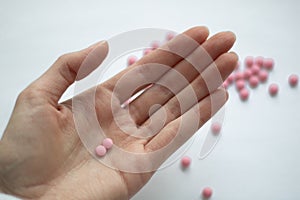 A hand with pink tablets on it