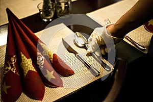 Hand placing dishes on Christmas New Year Holiday Table Setting Dinner Decorations Decor