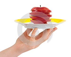 Hand with plate and chopped apple