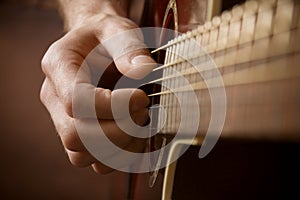 Hand playing acoustic guitar photo